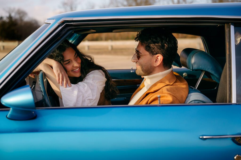 South jersey couple looking at each other in a blue vintage car